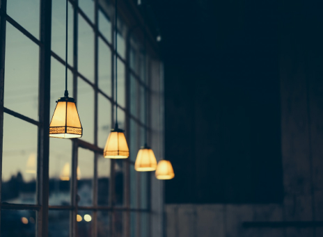 dim hanging lights in front of window at dusk