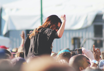 girl with sunglasees dancing at concert